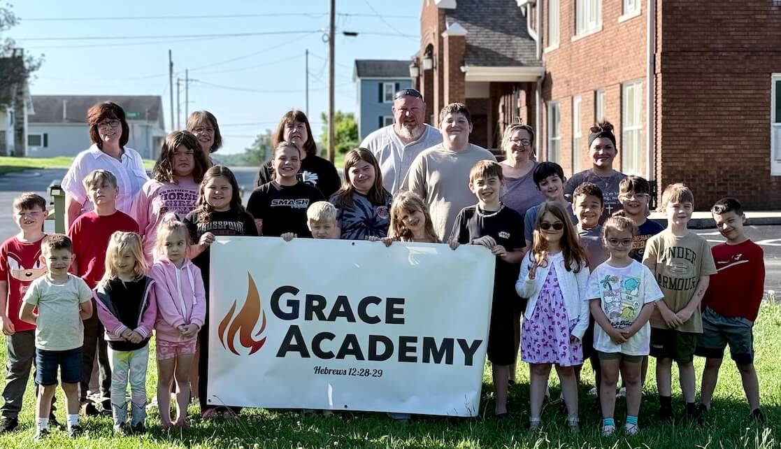Grace Academy Whole School photo Grace Academy student body 2026 in front of school holding banner with their logo